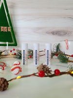 3 lip balms in paper tubes with winter decor in the background 